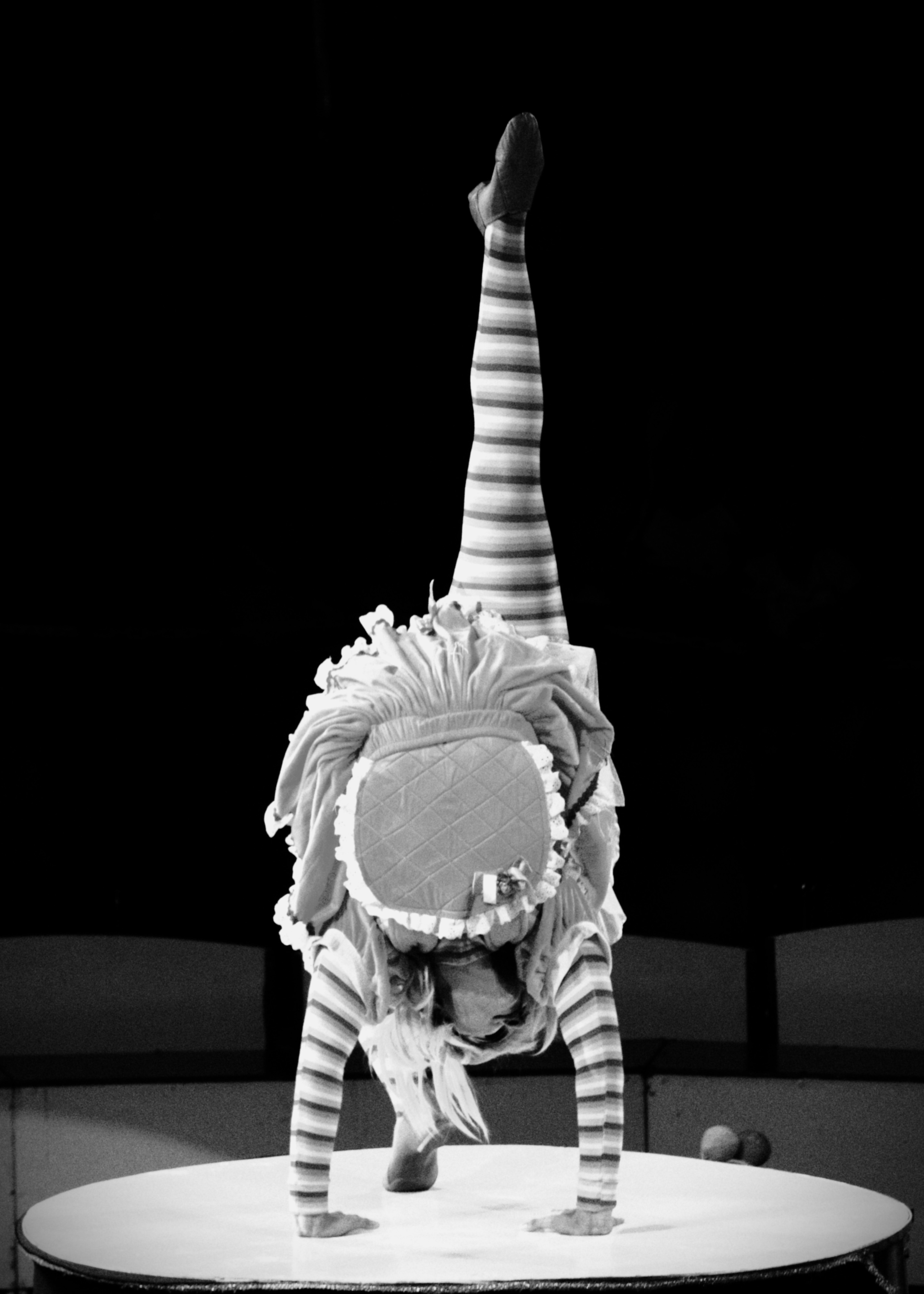 Contortionist with one leg raised perfectly vertical on table