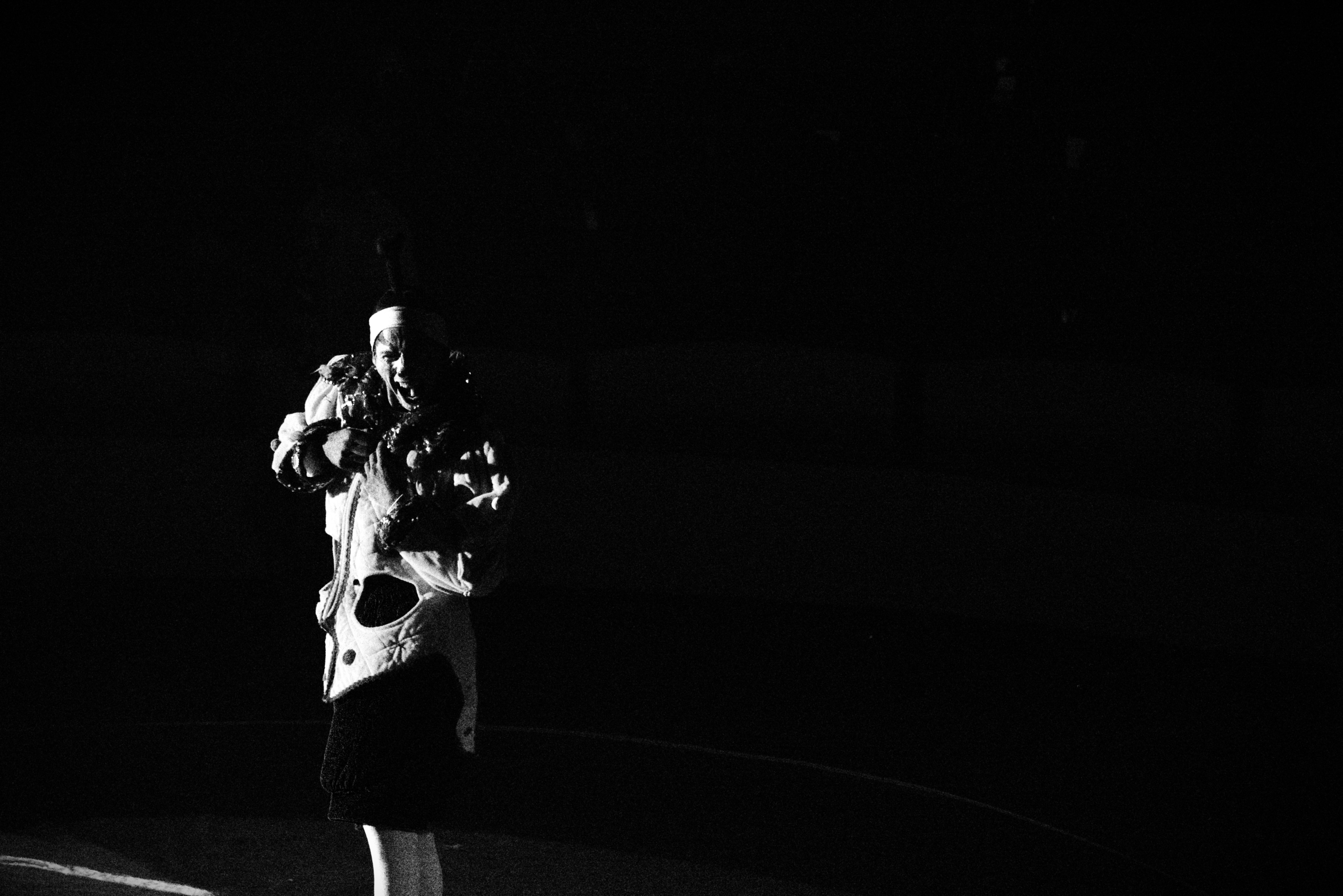 Solo clown performer under a single spotlight