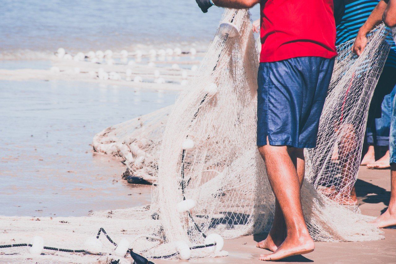 Close-up of fishermen's legs and hands hauling the seine
